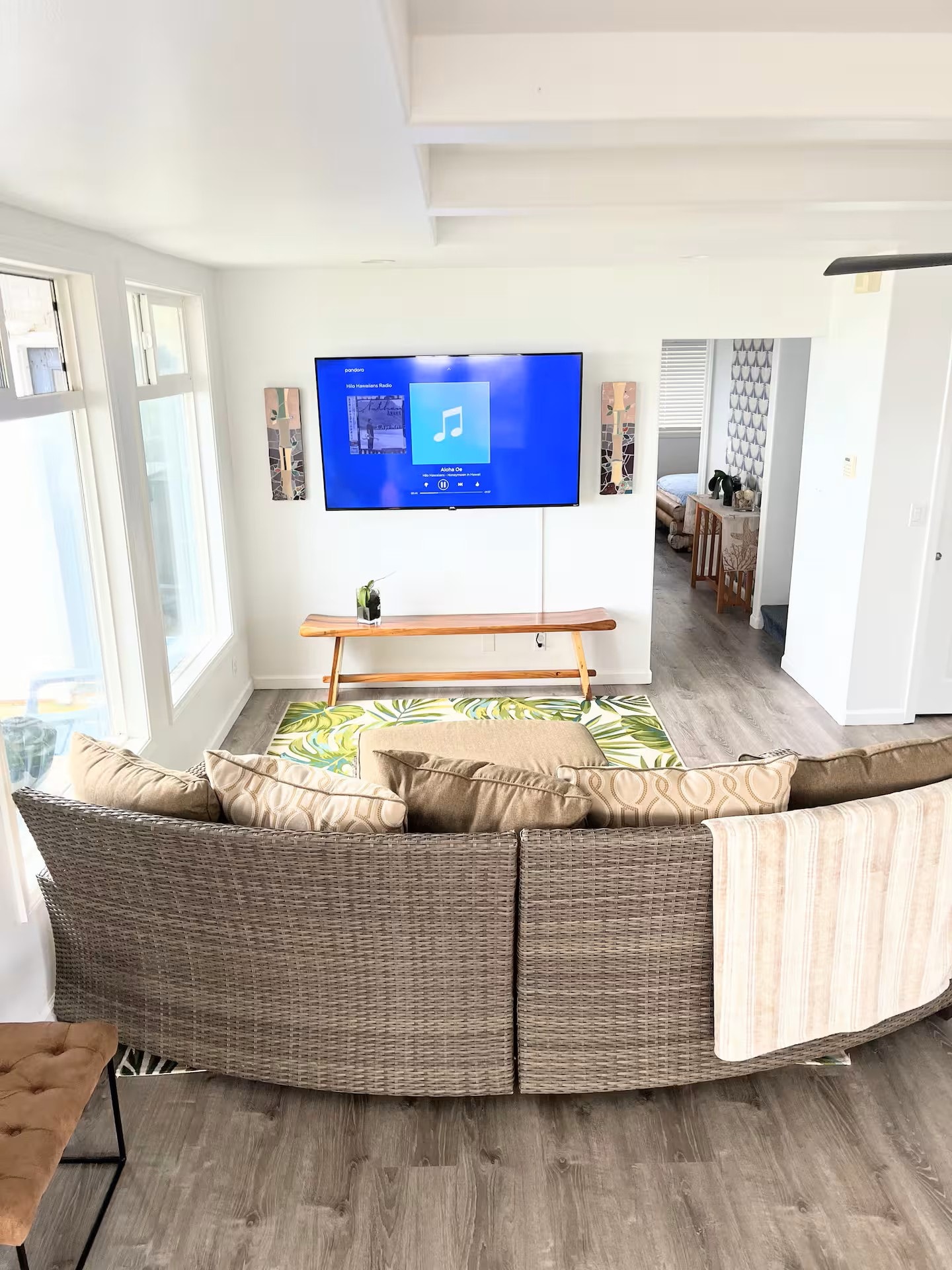 Living room with wicker sectional sofa and wall-mounted TV